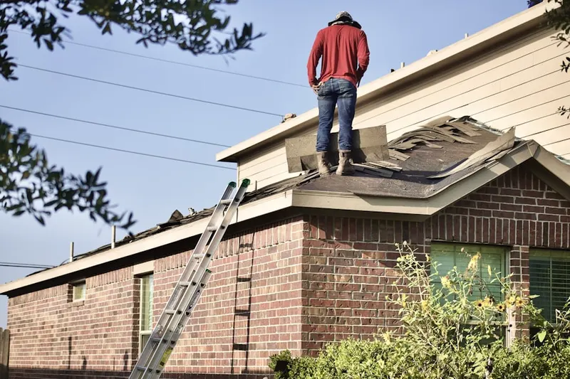 Professional roofer working on a residential roof in Saxony Manor